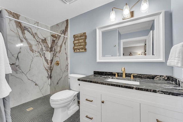 full bathroom featuring toilet, a marble finish shower, and vanity