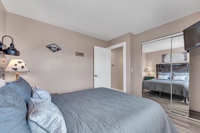 bedroom featuring a textured ceiling, a closet, and wood finished floors