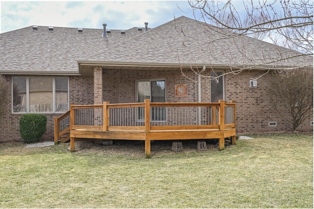 back of property featuring a shingled roof, a lawn, crawl space, a deck, and brick siding