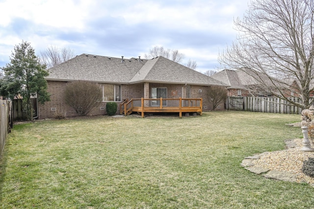 rear view of house with brick siding, roof with shingles, crawl space, a deck, and a fenced backyard