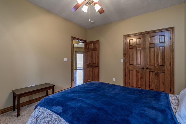 carpeted bedroom featuring a closet, baseboards, and a ceiling fan