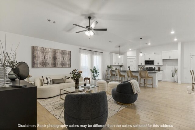 living room featuring visible vents, lofted ceiling, ceiling fan, light wood-style floors, and recessed lighting