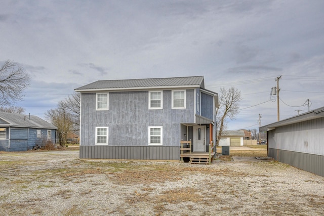 back of house featuring metal roof and central AC unit