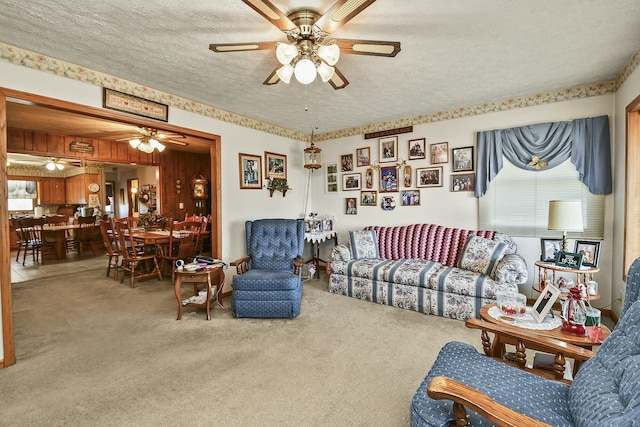 living room with a textured ceiling, carpet flooring, and a ceiling fan