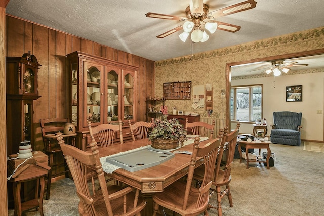 dining area with a textured ceiling, carpet flooring, and a ceiling fan