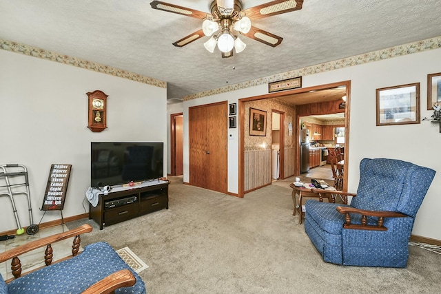 carpeted living room with a textured ceiling, a ceiling fan, and baseboards