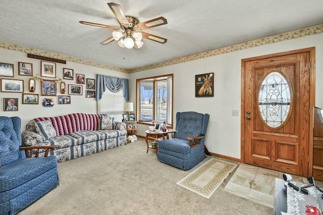 carpeted living area featuring a textured ceiling, a ceiling fan, and baseboards