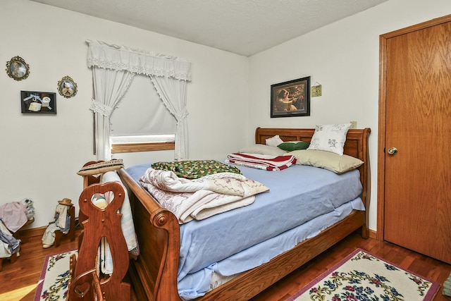 bedroom with wood finished floors and baseboards