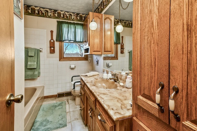 bathroom with tile walls, visible vents, toilet, vanity, and tile patterned flooring