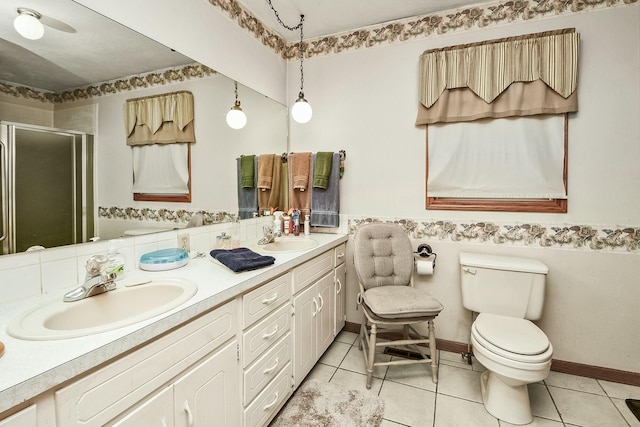 bathroom with double vanity, a sink, toilet, and a shower stall