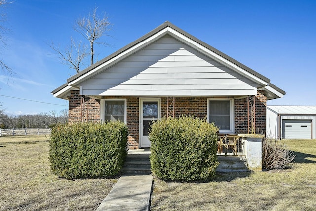 view of front of house featuring covered porch, brick siding, and a front lawn