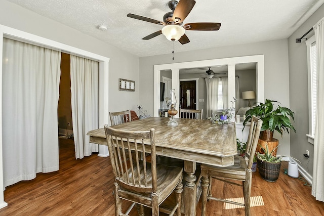 dining space featuring a wealth of natural light, ceiling fan, a textured ceiling, and wood finished floors