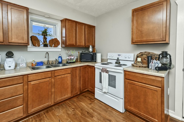 kitchen with white electric range oven, dark wood-style floors, a textured ceiling, black microwave, and a sink