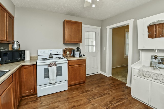 kitchen featuring black microwave, light countertops, brown cabinetry, white range with electric cooktop, and dark wood finished floors