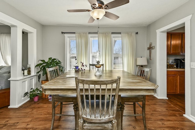 dining space with dark wood-type flooring and a ceiling fan