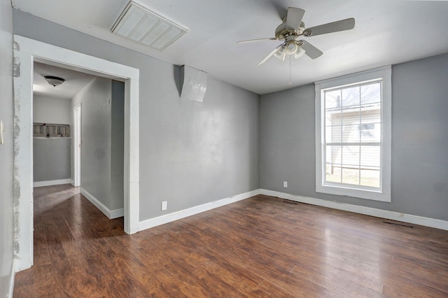 empty room featuring baseboards, visible vents, and wood finished floors