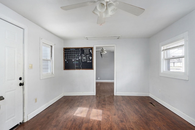 empty room featuring baseboards, visible vents, ceiling fan, and wood finished floors