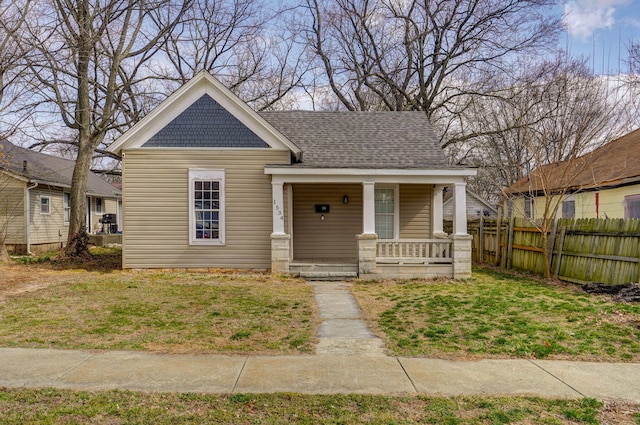 bungalow-style house featuring covered porch, a front yard, and fence