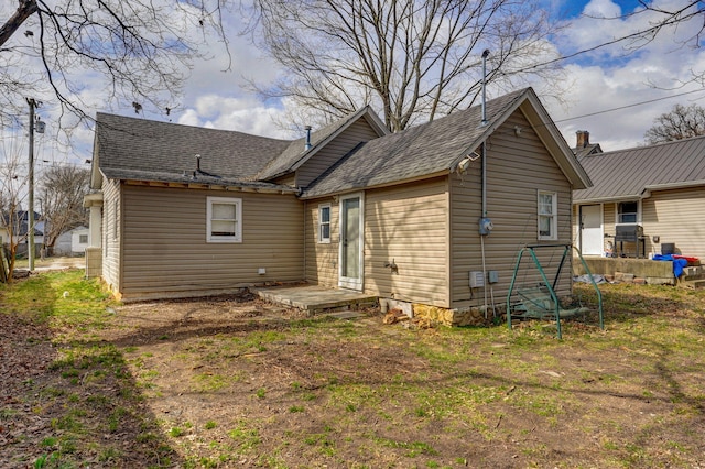 back of house featuring a shingled roof and a patio