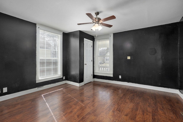 spare room with a ceiling fan, baseboards, and wood finished floors