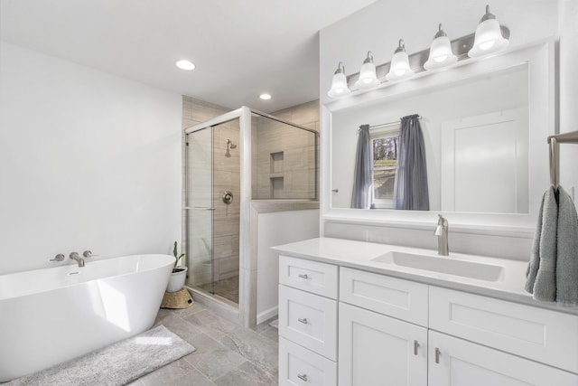 full bathroom featuring a stall shower, a freestanding tub, vanity, and recessed lighting