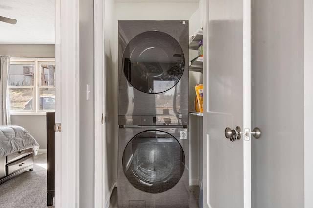 washroom featuring stacked washer and dryer, carpet flooring, and laundry area