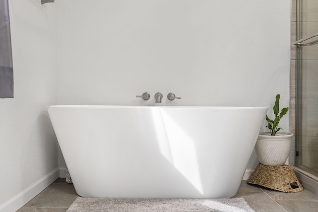 bathroom featuring a tile shower, a freestanding bath, and tile patterned floors