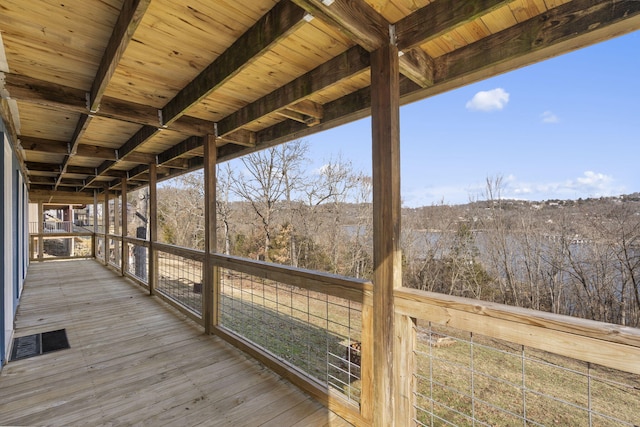 wooden terrace featuring visible vents and a view of trees