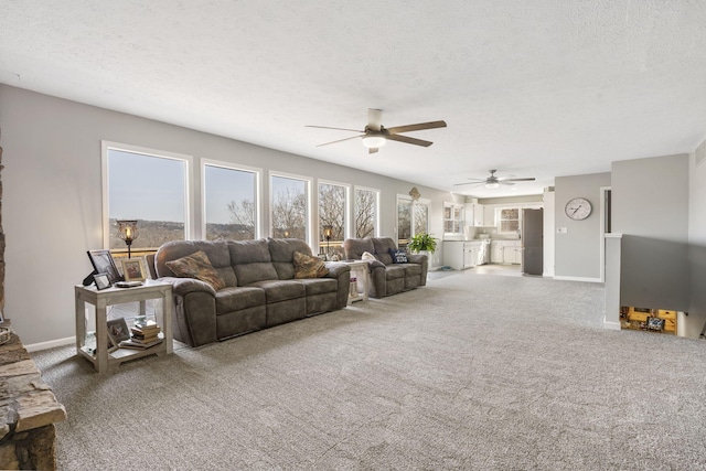 carpeted living room featuring a textured ceiling, a ceiling fan, and baseboards