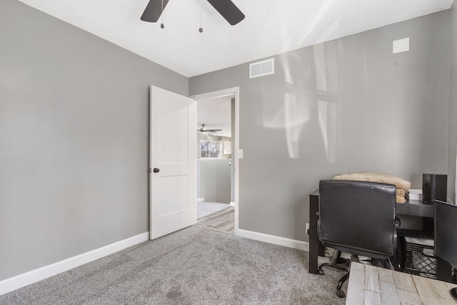 office area featuring carpet floors, visible vents, ceiling fan, and baseboards