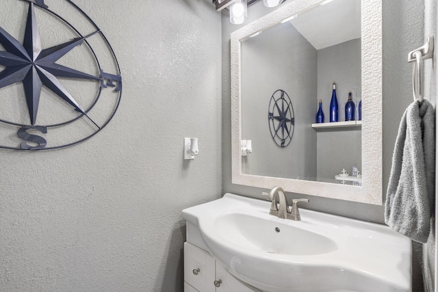 bathroom featuring a textured wall and vanity