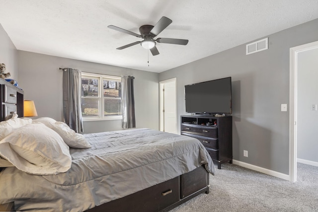 carpeted bedroom featuring a ceiling fan, visible vents, a textured ceiling, and baseboards