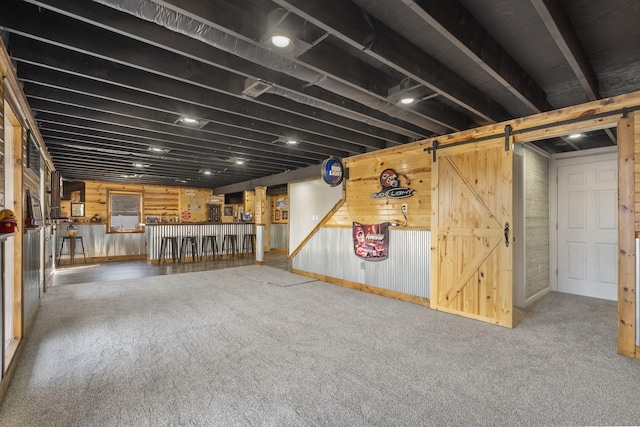 below grade area with carpet floors and a barn door