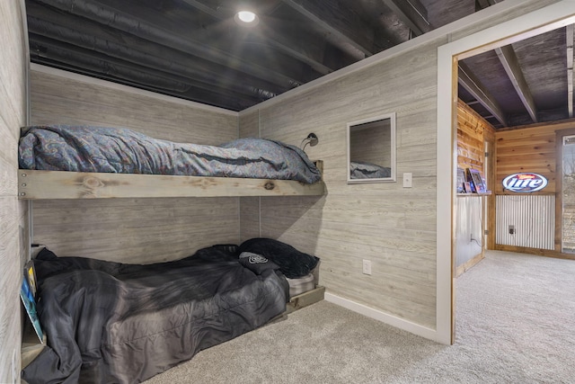 carpeted bedroom featuring wood walls and baseboards