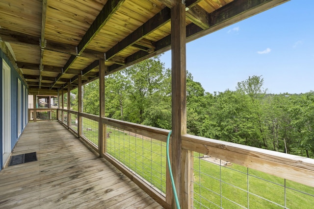deck featuring a lawn and a wooded view