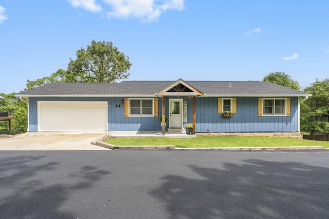 single story home featuring a shingled roof, board and batten siding, an attached garage, and concrete driveway