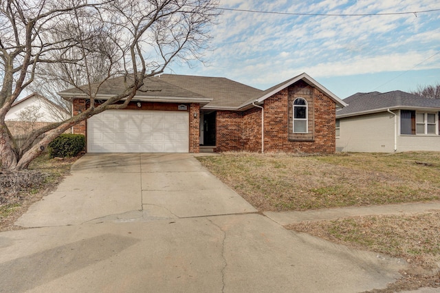 ranch-style home with brick siding, a shingled roof, concrete driveway, an attached garage, and a front yard