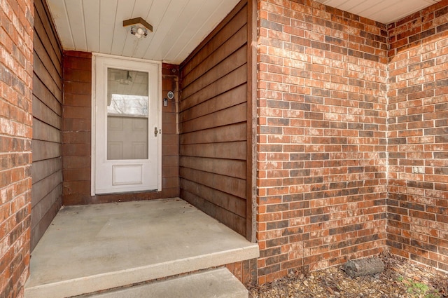 entrance to property featuring brick siding