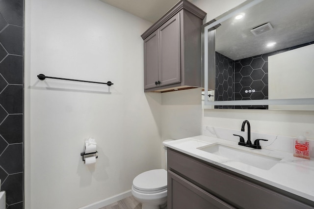 full bath featuring a shower, visible vents, toilet, vanity, and baseboards