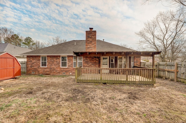 rear view of house featuring brick siding, a chimney, a storage unit, a fenced backyard, and an outdoor structure