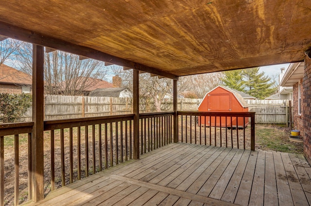 deck featuring a storage shed, a fenced backyard, and an outdoor structure