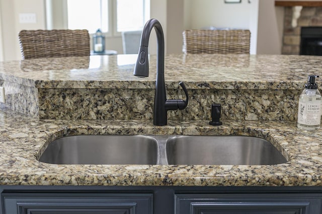 kitchen featuring a sink and light stone countertops