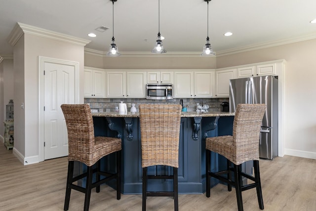 kitchen with appliances with stainless steel finishes, white cabinets, ornamental molding, and visible vents