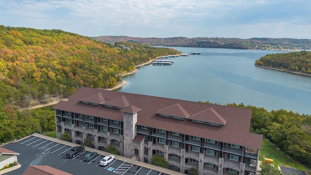 birds eye view of property featuring a forest view and a water view