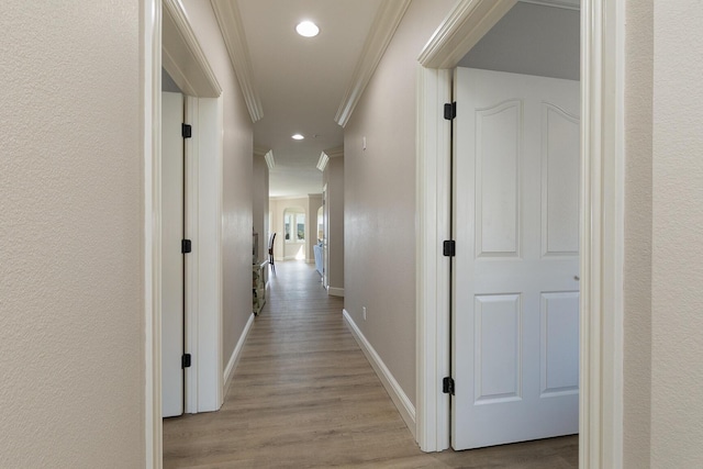 hall featuring baseboards, recessed lighting, wood finished floors, and crown molding