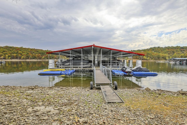 view of dock featuring a forest view and a water view