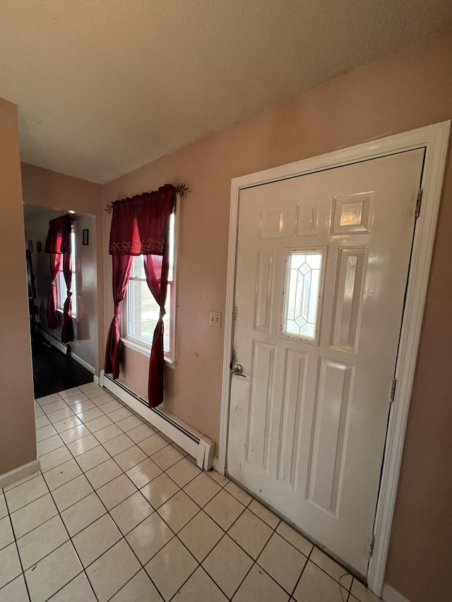 foyer entrance with baseboard heating and light tile patterned floors