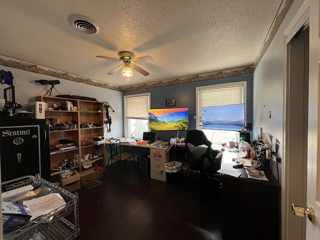 office area featuring dark wood-style floors, a textured ceiling, visible vents, and a ceiling fan