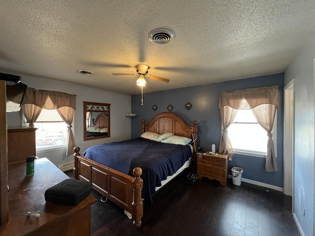 bedroom featuring hardwood / wood-style flooring, baseboards, visible vents, and ceiling fan