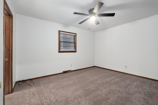 carpeted empty room with a ceiling fan, visible vents, and baseboards